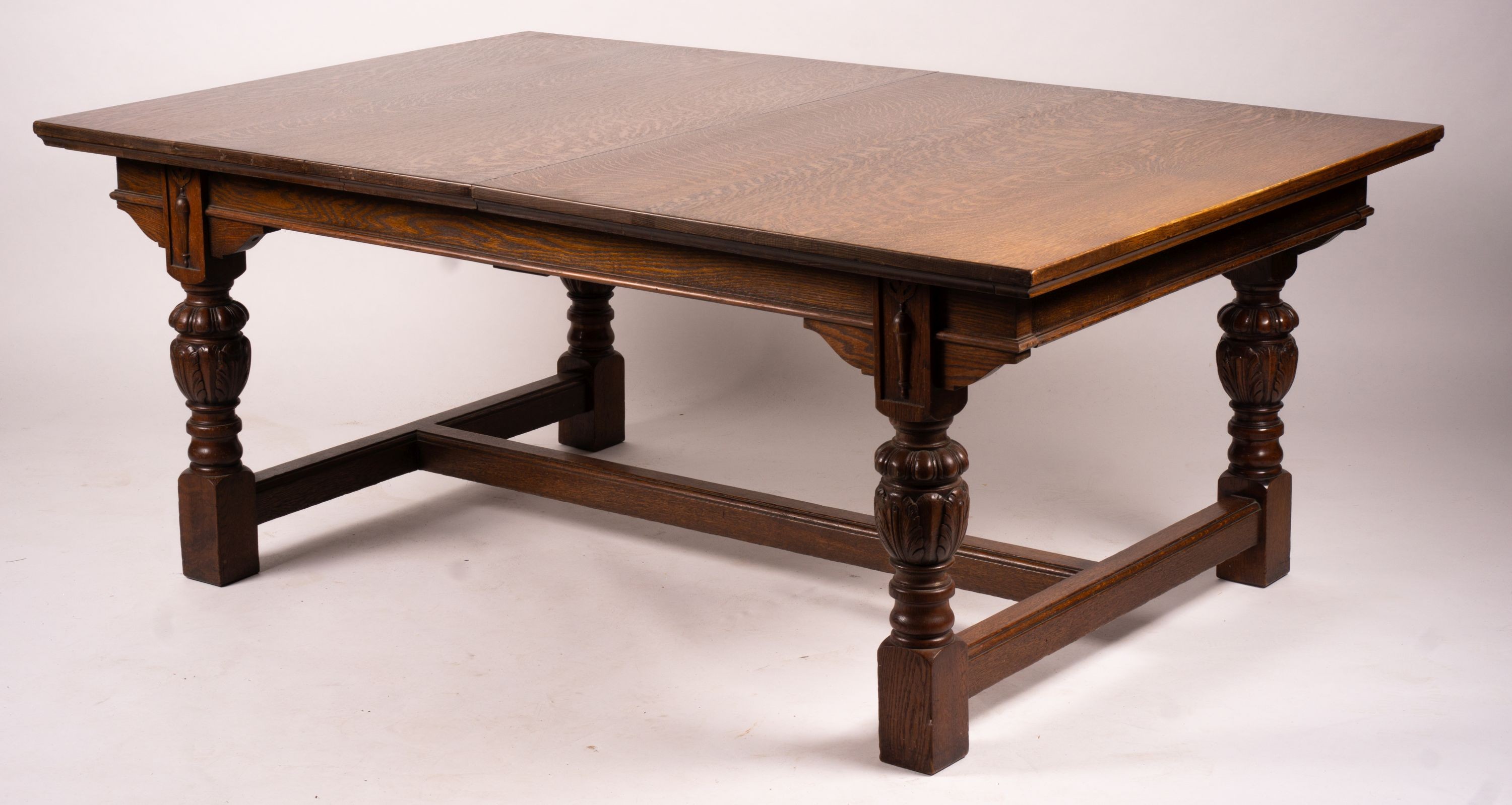 A 17th century style carved rectangular oak extending dining table with 'H' stretcher, 300cm extended, two spare leaves, width 121cm, height 75cm